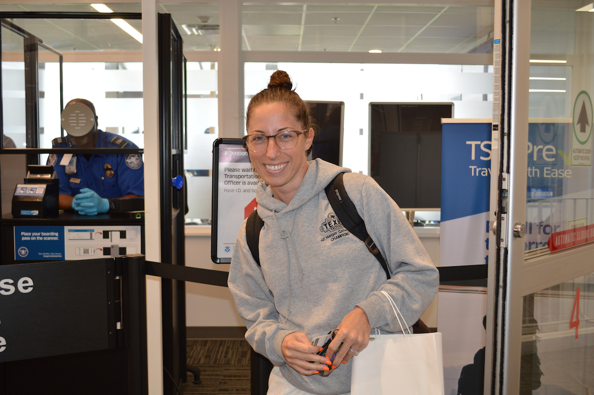 A smiling passenger as she passes through TSA screening at Wilmington Airport ILG