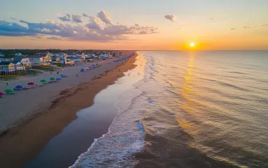 Rehoboth Beach Delaware seashore during sunset with beachgoers and umbrellas